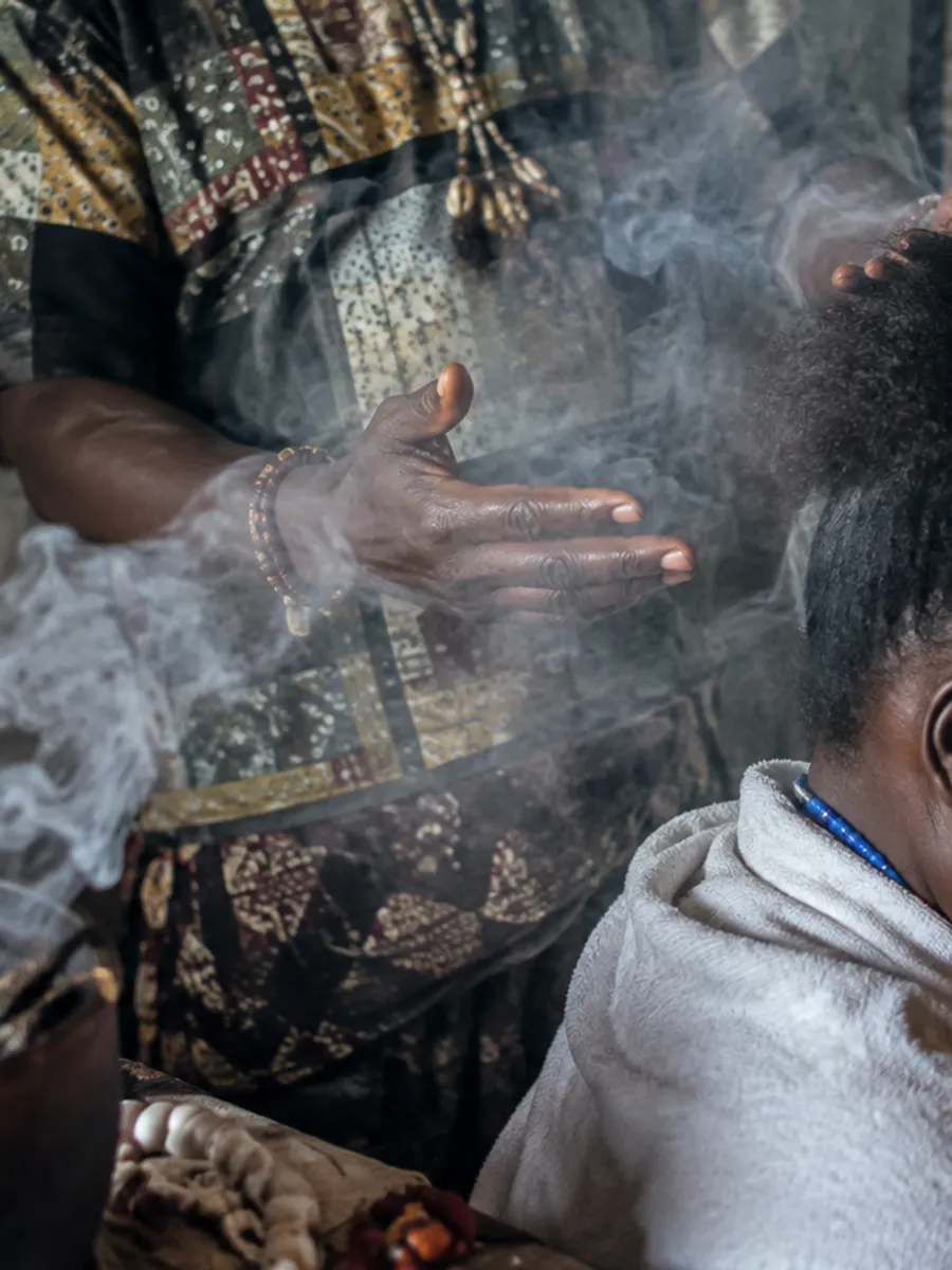 Fumigation de purification passée au-dessus de la tête d’une personne assise